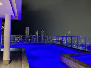 a swimming pool on the roof of a building with a city skyline at Signature Point Bella Vista, Sea View 2 BR in Panama City