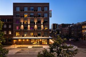 a tall building with a sign on it in a city at Moxy Omaha Downtown in Omaha