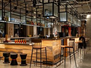 a bar with a wooden counter and chairs at Moxy Omaha Downtown in Omaha