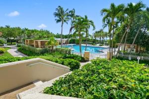 マイアミにあるApartment Located at The Ritz Carlton Key Biscayne, Miamiのヤシの木と茂みのあるリゾートプール