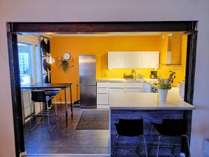 une cuisine avec des murs jaunes, une table et des chaises dans l'établissement Big 88m2 apartment in the center, à Rovaniemi