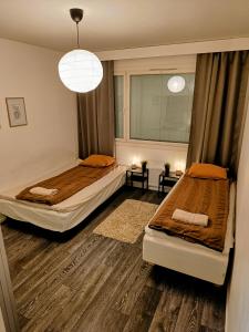 - une chambre avec 2 lits et une fenêtre dans l'établissement Big 88m2 apartment in the center, à Rovaniemi