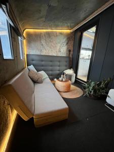 a living room with a couch and a window at Storjord Farmstay Glamping in Tromsø