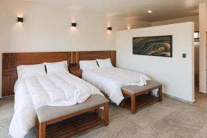 sypialnia z 2 łóżkami z białą pościelą w obiekcie PiedraViva Tepoztlán w mieście Tepoztlán