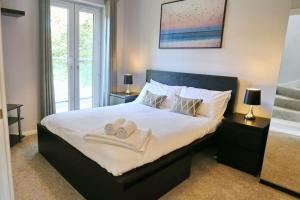 a bedroom with a large bed with towels on it at Luxurious Townhouse In Central Manchester in Manchester