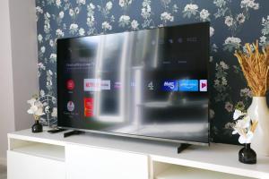a flat screen tv sitting on top of a white cabinet at Luxurious Townhouse In Central Manchester in Manchester