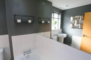 a bathroom with a white tub and a sink at Luxurious Townhouse In Central Manchester in Manchester +27 photos