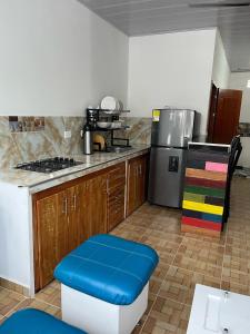 a kitchen with a stove and a blue stool at Cabaña Santorini Colombiano in Puerto Triunfo