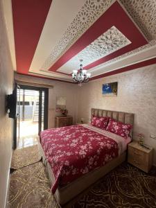 1 dormitorio con cama con sábanas rojas y techo en APPART HOTEL OUED EDDAHAB, en Khenifra