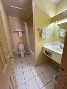 Executive Inn & Suites Lackland AFB في سان انطونيو: حمام مع حوض ومرحاض