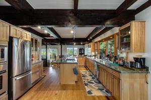 a large kitchen with wooden cabinets and stainless steel appliances at Charming Farmhouse Amongst The Vines in Healdsburg