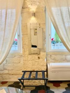 a room with a bench and two windows at LA SUITE DE TURRITAN in Sassari