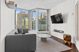 a living room with a couch and a large window at Downtown Luxury 1BR Coal Harbour in Vancouver