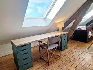 a desk with a chair in a room with a window at L'Urbain YourHostHelper in Cherbourg en Cotentin