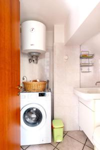 a bathroom with a washing machine and a sink at Villa Aura in Marina di Modica