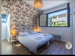 Un dormitorio con dos camas y una ventana en Gîte de la Pépinière, en Argelès-Gazost