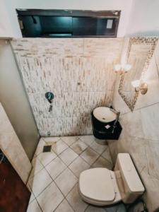 - une salle de bains sale avec toilettes et fenêtre dans l'établissement Posada San Miguel, à Paraguarí