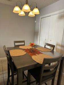a dining room table with four chairs and a table with flowers at GoddessLiving Luxury Town Home in Nashville