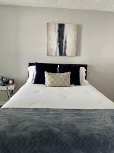 a bedroom with a large white bed with a painting on the wall at GoddessLiving Luxury Town Home in Nashville