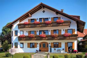 uma grande casa branca com flores na varanda em Gästehaus Sonner em Dietmannsried