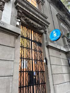 a building with a door with a blue sign on it at Hostel Home in Mexico City