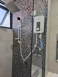 a shower in a bathroom with a glass door at The Seashore House, The Shore Kota Kinabalu in Kota Kinabalu