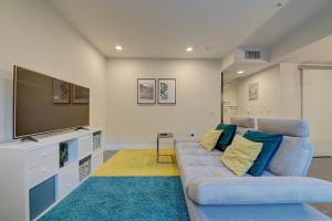 uma sala de estar com um sofá azul e uma televisão de ecrã plano em Cozy Apartment in the Heart of LA em Los Angeles
