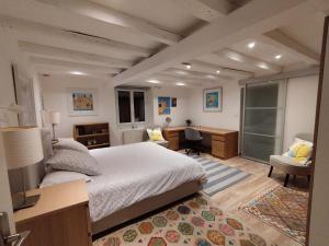 una camera con un grande letto, una scrivania e una scrivania di Le Tilleul a Sciez