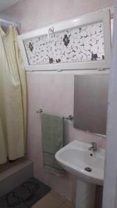 uma pequena casa de banho com um lavatório e um espelho em Stay at Kety`s II em Praia