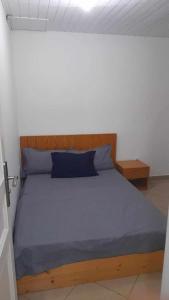 Schlafzimmer mit einem großen Bett mit einem Kopfteil aus Holz in der Unterkunft Stay at Kety`s II in Praia