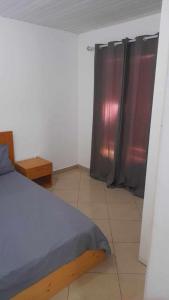 ein Schlafzimmer mit einem Bett und Vorhängen in einem Zimmer in der Unterkunft Stay at Kety`s II in Praia