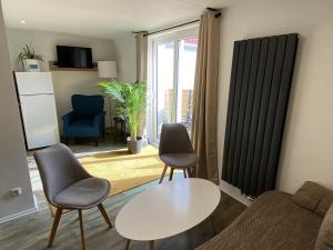 uma sala de estar com um sofá, uma mesa e cadeiras em Ferienwohnung Happynest em Jena