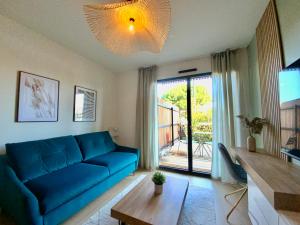 佩羅勒的住宿－Les Loges de la Mer - Pérols，客厅设有蓝色的沙发和大窗户