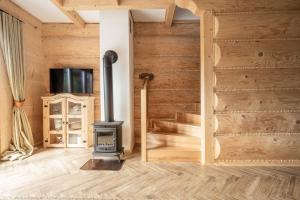a woodburning stove in a room with a sliding door at Zacny Lasek in Poronin