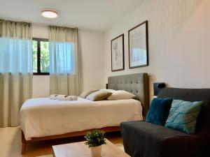 - une chambre avec un lit et un canapé dans l'établissement Les Loges de la Mer - Pérols, à Pérols