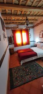 1 dormitorio con 2 camas y ventana en Auberge des peupliers Café Restaurant, en Akhendachou nʼAït Ouffi