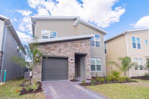 a house with a garage in front of it at Beautiful 5bedroom house close to Disney 8943 in Kissimmee