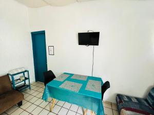 Cette chambre dispose d'une table bleue et d'une télévision murale. dans l'établissement Departamento Tacuba, à Mexico