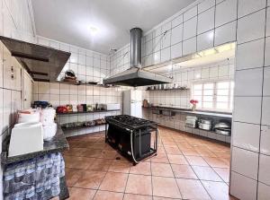 uma grande cozinha com um fogão no meio em Sítio em Atibaia em Atibaia