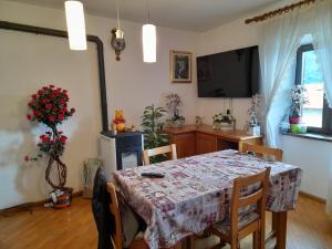 Bedollo的住宿－la casa del zio Bepi，一间带桌子和电视的用餐室