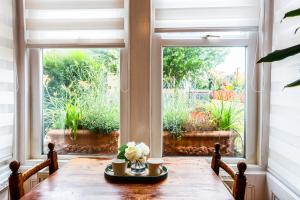 a table with flowers on it in front of a window at Lovely&Bright Studio Flat Close to Central London in London