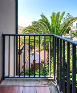 a balcony with a view of a palm tree at Villa Aura in Marina di Modica