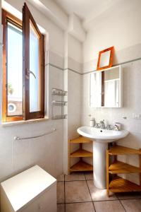 a white bathroom with a sink and a window at Villa Aura in Marina di Modica