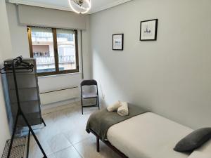 a bedroom with a bed and a chair and a window at Exclusiva vivienda en el centro de Salamanca in Salamanca