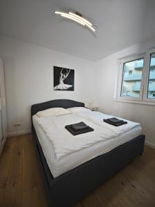 a bedroom with a large bed with black and white sheets at Bella's Appartment - Beautiful, modern and next to metro in Vienna