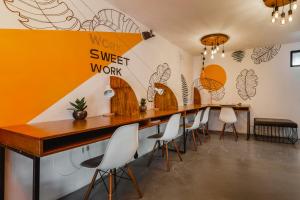 a long table in a room with white chairs at Mezcal Hostel in Cancún