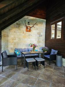 a patio with couches and tables and a window at Misha's House in Porumbacu de Sus