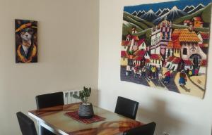 a dining room table with a painting on the wall at Acogedoras vistas al illimani, cálido y accesible in La Paz