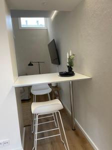 a white desk with two stools in a room at Cozzy apartment in old Rauma in Rauma