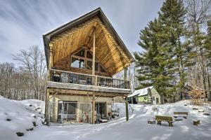 une cabine dans les bois dans la neige dans l'établissement Quiet Adirondack Cabin on Private Lake!, à Glenfield